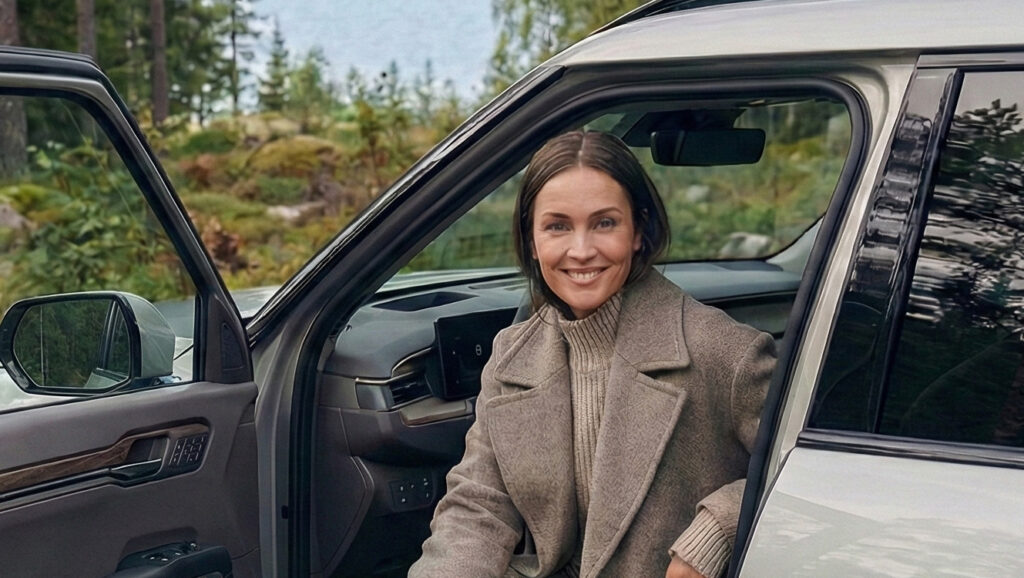 Kvinna i elbil som installerat laddstolpar med laddboxar i en brf